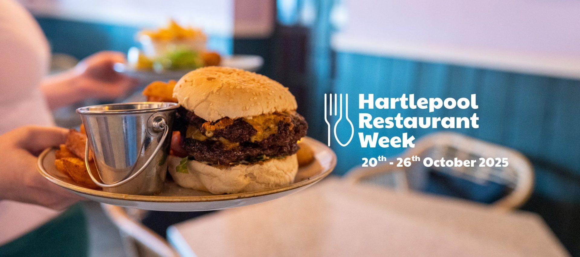 Person serving burger and potato wedges. Hartlepool Restaurant Week 20th-26th October 2025.