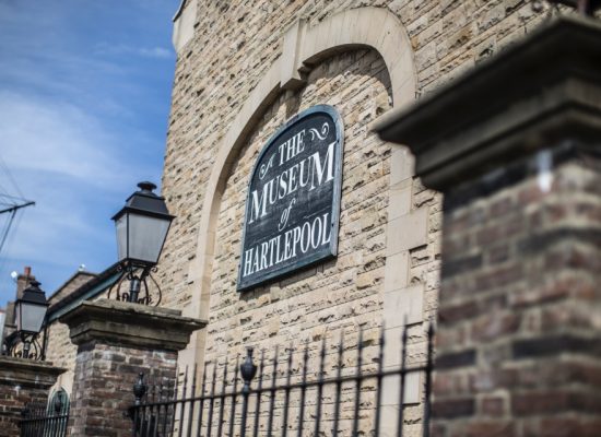 Museum of Hartlepool sign on a brick wall with old-fashioned lantern in front.
